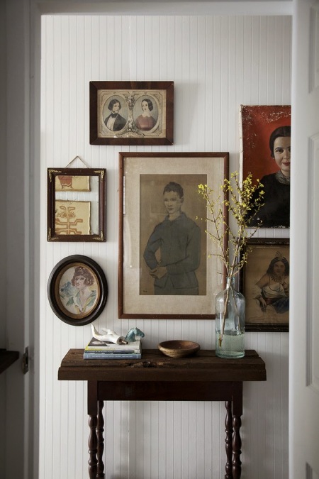 Biała boazeria na ścianie z retro obrazami w stylowych ramach z drewna