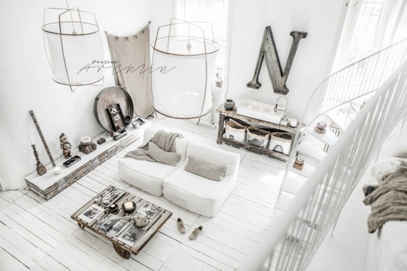 Przestronny salon w białym kolorze z drewnianą podłogą