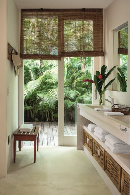 Bambusowe rolety,drewniane wieszaki,wiklinowe pojemniki i kosze w aranzacji łazienki z biała podłogą w naturalnym wystroju