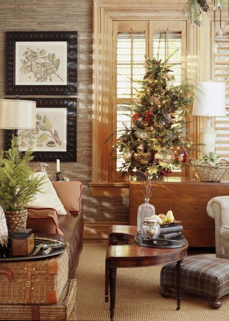 Bambusowe walizki,białe klasyczne lampy stołowe,drewniany kolonialny stolik pomocniczy,kraciasty puf i świateczna choinka w tradycyjnej dekoracji bożonarodzeniowej