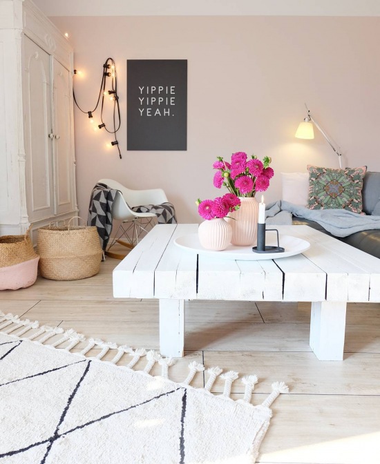 Różowy salon z białym stolikiem kawowym z drewna