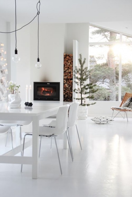 Biały salon z kominkiem ze świąteczną choinką w stylu skandynawskim