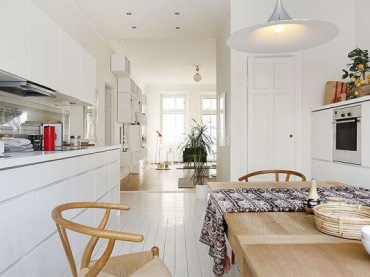 Otwarta przestrzeń białej kuchni z jadalnią i salonem (20955)
