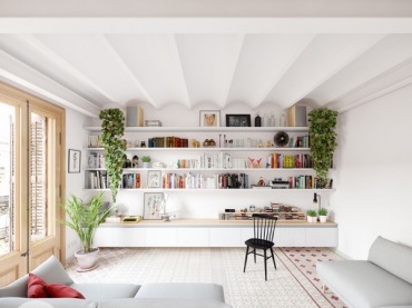 Przestronny salon w bieli z zabudowaną domową biblioteczką na węższej ścianie i... bardzo oryginalnym sufitem! Rośliny...