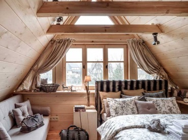 W sypialni znajduje się wąskie dwuosobowe łóżko i rozkładana kanapa. Niezwykły klimat poddasza potęgują drewniane...