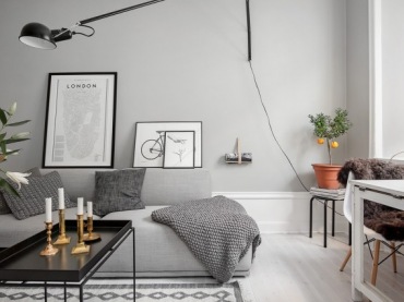 Skandynawskie grafiki,czarny stolik kawowy z tacą blatem,biało-czarny dywan skandynawski i biała podłoga w szarym salonie (26776)