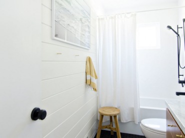 Jedną ze ścian wyłożono białymi panelami z drewna, potęgując przytulny klimat. Aranżację łazienki uzupełniają detale,...