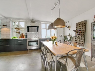 Drewniana tablica na przechowywanie wina,industrialny stół z drewnianym blatem,szare krzesła paris i czarne szafki kuchenne w otwartej jadalni z kuchnią (26626)