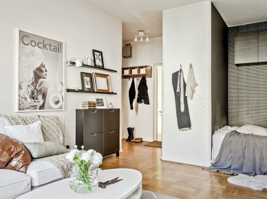 Otwarty salon z wnęką z łóżkiem, biało-czarna dekoracja salonu,czarne półeczki z ramkami (28486)