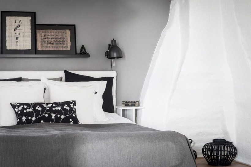 Szare ściany,szara narzuta,biało-czarne poduszki dekoracyjbne w sypialni