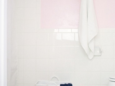 Aranżacja łazienki opiera się na inspiracji stylem minimalistycznym. Biały kosz stojący pod ścianą, idealnie komponuje...