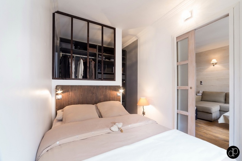 Mini sypialnia połączona z przedpokojem ze szklabną ścianką działową w czarnych metalowych ramach