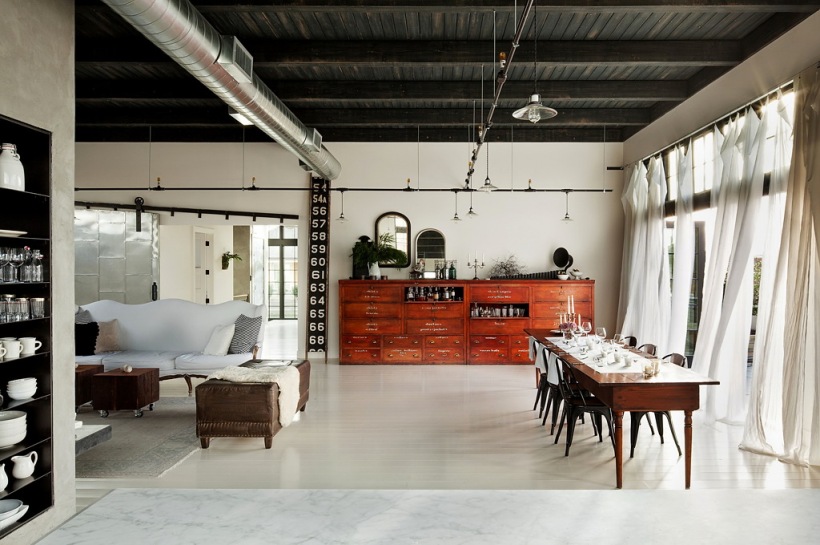 Drewniana czarna podbitka sufitowa,biała podłoga żywiczna,stylowy drewniany stół z tolixami i stylowa prowansalska biała sofa w salonie