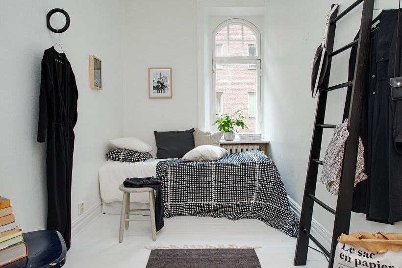 Biało-czarna sypialnia w stylu skandynawskim z czarną dekoracyjną drabiną
