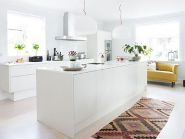 Kolorowy tkany dywan i żółta sofa w białej kuchni (48550)