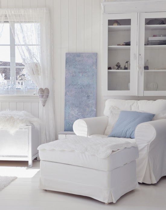 Niebieska poduszka i dekoracje w białym salonie w stylu romantycznym