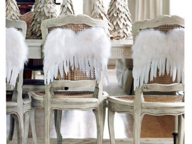 Pierzaste białe skrzydełka aniołowe na prowansalskich krzesła przy sjadalnianym stole światecznym z dekoracyjnymi ośnieżonymi choinkami (27431)