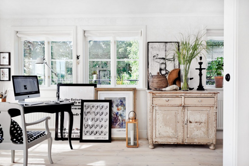 Czarna stylowa konsolka i białe krzesło w stylu francuskim,komoda vintage,typogeafie i grafiki stojace na podłodze w aranżacji otwartego salonu