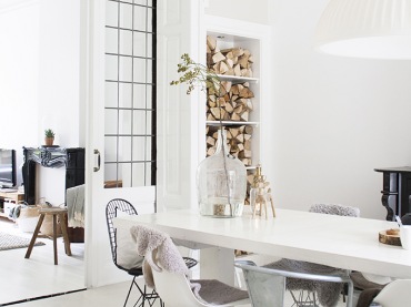 Uroczy domek skandynawski - cały biały, ale z wyrazistym i stylowym kominkiem w salonie. Białe wnętrza skontrastowane...
