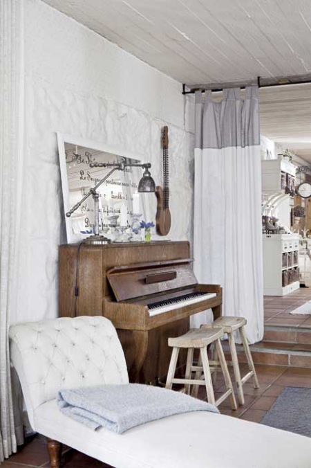 Stylowy szezlong,pianino,bielone tynki,drewniane taborety i industrialna lampka