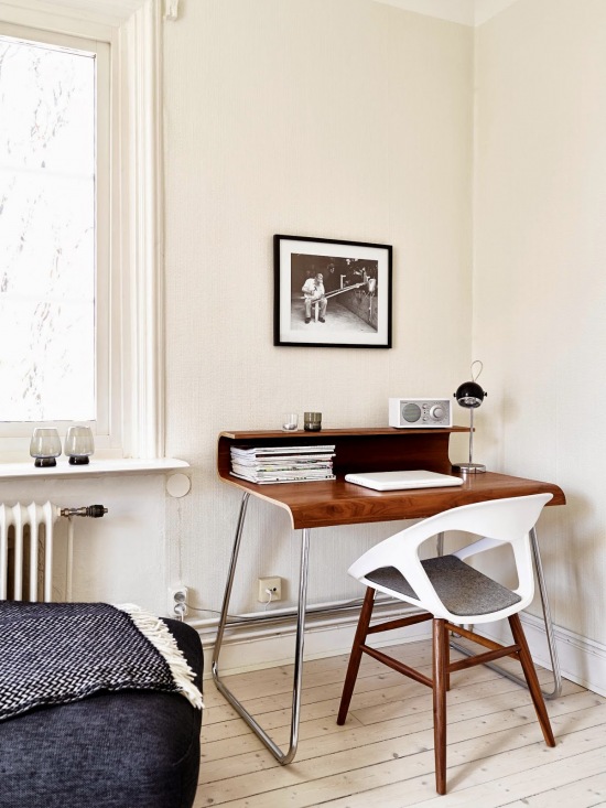 Profilowany brązowy blat biurka z półką na metalowych płozach z drewnianym krzesłem z białym siedziskiem