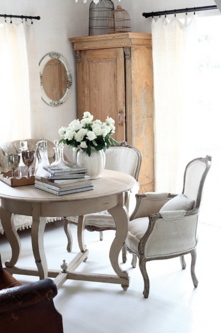 Stylowa jadalnia z francuskim okrągłym stołem i krzesłami , z szafą i lustrem w stylu shabby