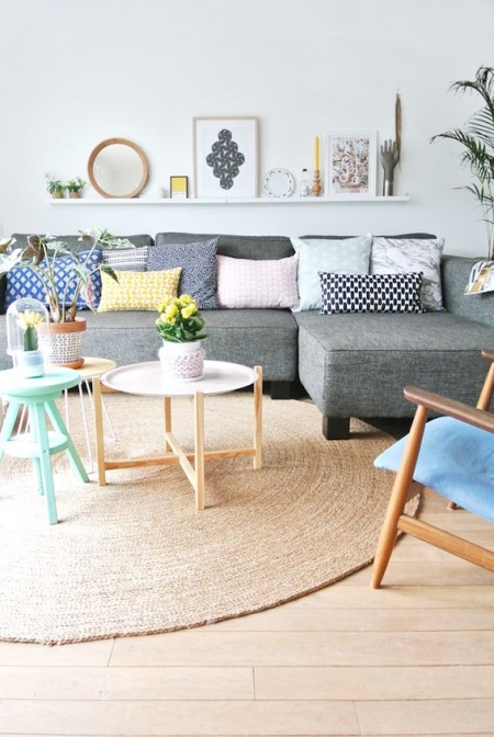Szara sofa udekorowana kolorowymi poduszkami