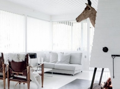Biały salon skandynawski z kominkiem,brązową głową renifera i brązowymi fotelami (47690)