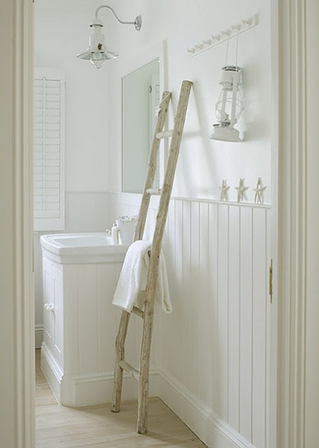 Biała łazienka z drewnianą drabiną  latarenką w marynistycznym stylu