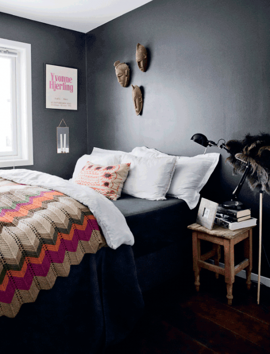 Dziergana kolorowa narzuta w zygzaki i czarna ściana w sypialni