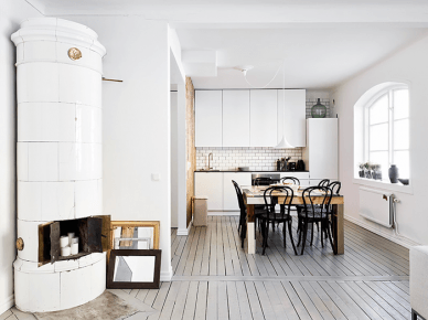 Biała kuchnia skandynawska z drewnianym stołem,czarnymi krzesłami i szarą podłogą z desekz (21950)