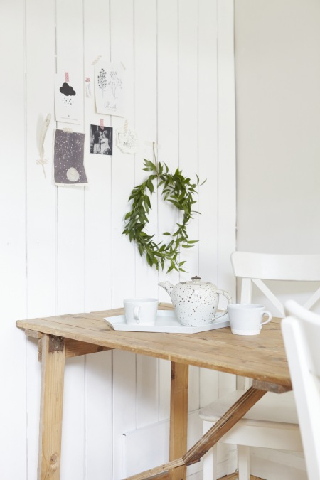 Białe deski na ścianie i drewniany stół w aranżacji rustykalnej jadalni