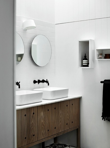 Okragłe lustra,czarne baterie retro,drewniane rustykalne szafki pod prostokatnymi umywalkami,drewniane biale panele na ścianie i biało-czarna marokańska  terakota w łazience