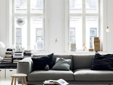 Jasnoszara sofa w nowoczesnym stylu i żarówka na kablu w skandynawskim salonie (22386)