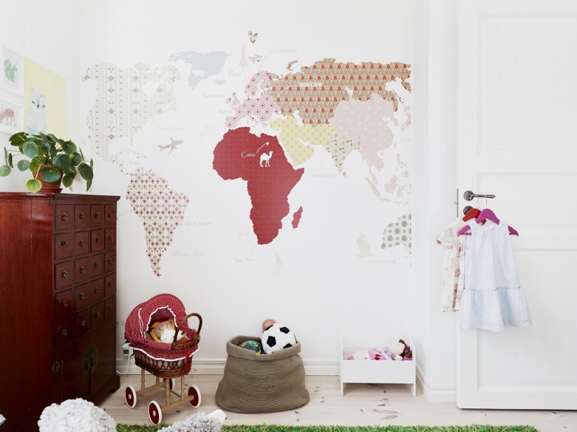 Naklejka-fototapeta z mapą świata na ścianie w pokoju dziecięcym z komodą z szufladkami