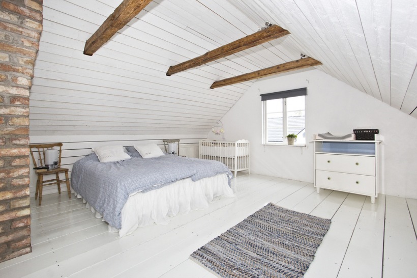Sypialnia ze ścianą z cegły i drewnianymi belkami