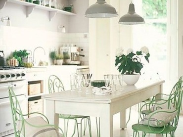 W biało-miętowej kuchni podłogę wyłożono drewnianymi deskami. Wnętrze jest bardzo eleganckie i nieco romantyczne przez krzesła z rzeźbionymi...