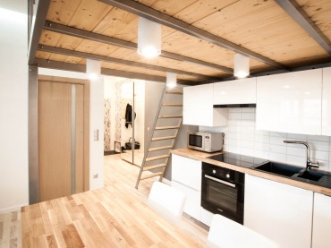W kuchni białe szafki z lekkim połyskiem idealnie podkreślają nowoczesny charakter całego mieszkania. Jednocześnie rozświetlają nieco tę przestrzeń, która z powodu obniżonego sufitu ma mniejszy dostęp światła niż np....