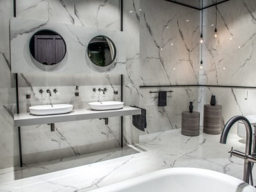 Aranżacja łazienki przewiduje dwa stanowiska z dwoma umywalkami i lustrami. Biało-szary kamień dodaje jej elegancji....