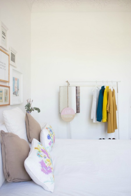 Aranżacja białej wysokiej sypialni z kolorowymi dodatkami