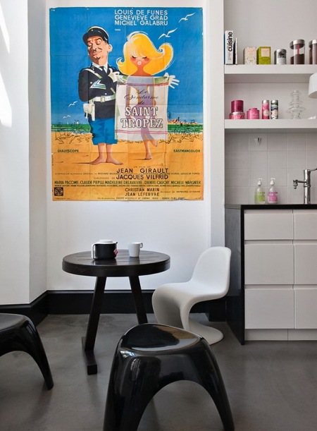 Kolorowy plakat filmowy na ścianie w kącku z zestawem mebli dziecięcych - stolik z krzesłami panton