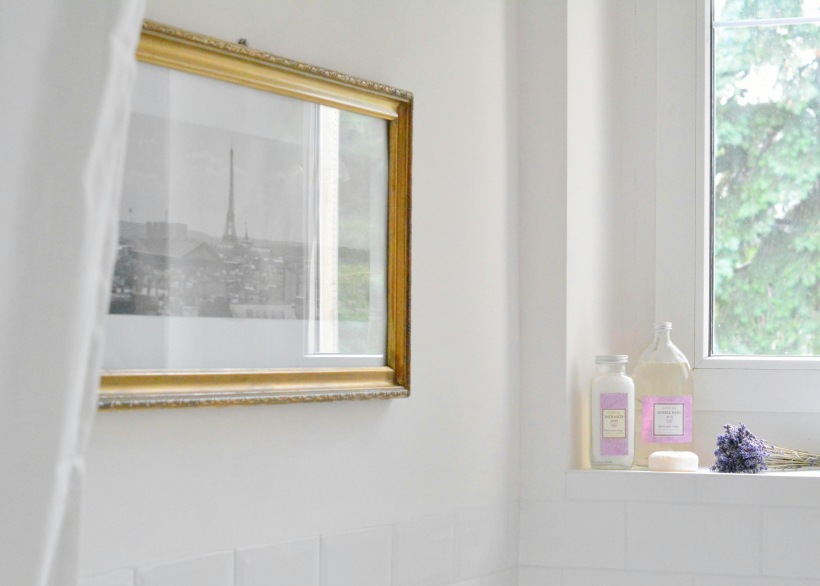 Fotografia z Paryża w złotej ramie w aranżacji łazienki