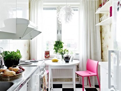 Biała mała kuchnia z różowym krzesłem iczarno-białą posadzką (20438)