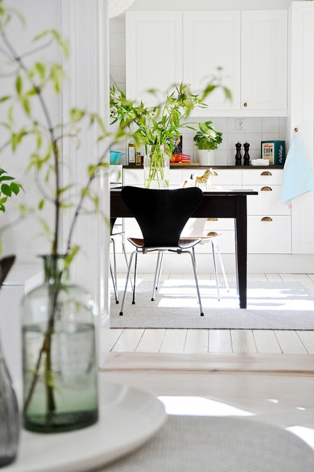 Drewniany ciemny stół w białej kuchni skandynawskiej