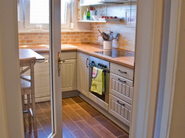 Mała kuchnia spełnia wszystkie swoje funkcje oraz zapewnia całkiem wygodne warunki do codziennego użytkowania. Białe szafki i drewniane blaty wprowadzają do niej charakter stylu...
