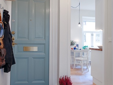 nietypowa aranżacja w skandynawskim stylu - dużo tu ciepłych detali w stylu vintage, które tworzą ciekawą mieszankę stylową. Niebieskie drzwi i inne detale wprowadzają łagodnie kolor do wnętrza, które ciepło złamane są odcieniami brązu...