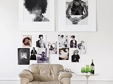 Czarno-białe fotografie w antyramach na białej ścianie w nowoczesnej aranżacji ze skórzanym fotelem i bialym okragłym stolikiem (24617)