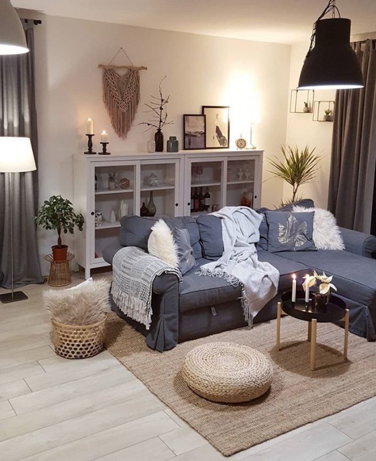 Przytulny salon z szarą sofą i dekoracją z pledów i poduszek