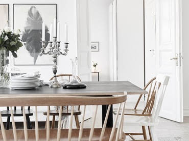 Skandynawska drewniana ławka przy stole na kozłach w białej jadalni z nowoczesnymi grafikami na ścianie (48134)