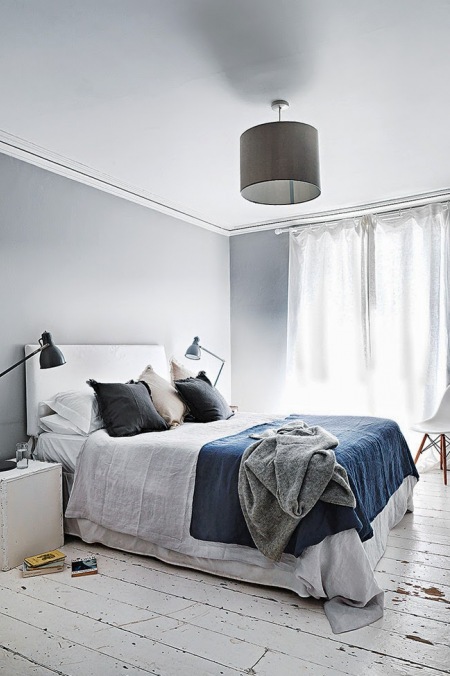 Szaro-niebieska sypialnia z czarną lampą i białą podłogą z desek
